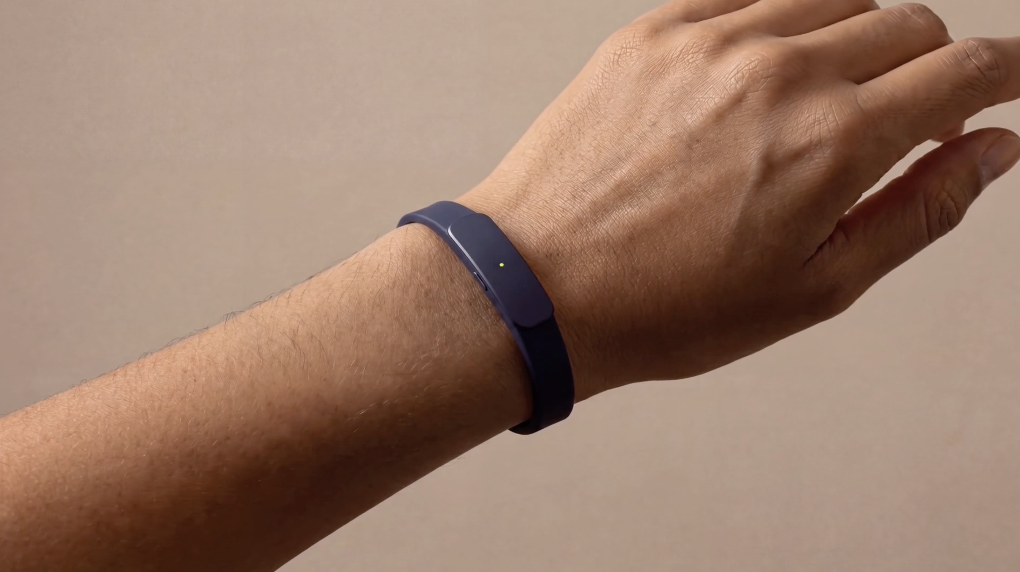 The Larkin wristband resting on a desk beside a phone
