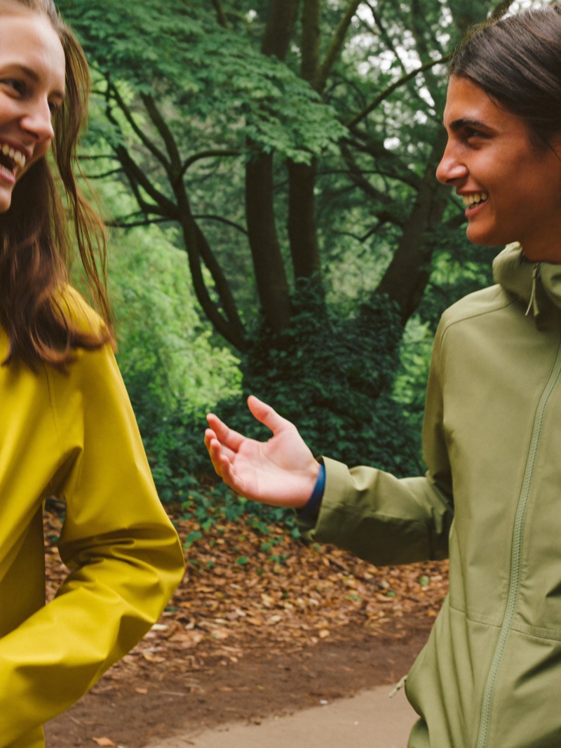 Two friends laughing on a walk through a green park